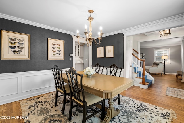 dining space with an inviting chandelier, hardwood / wood-style flooring, and crown molding