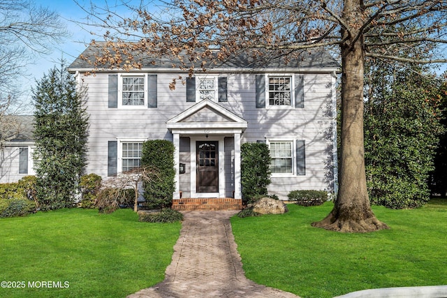 colonial-style house featuring a front yard