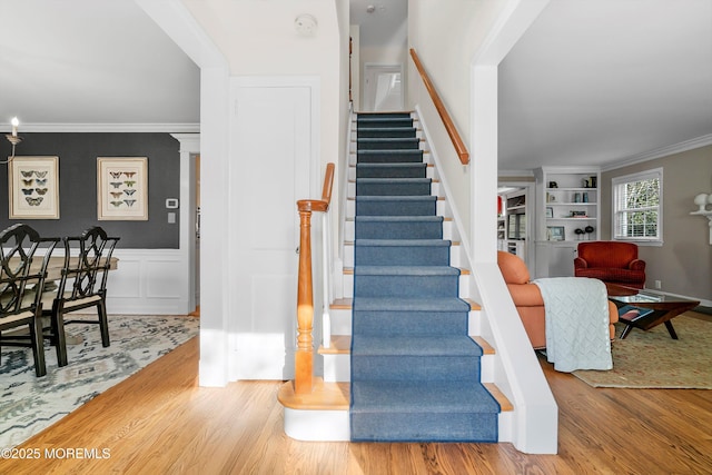 stairway featuring hardwood / wood-style flooring and ornamental molding