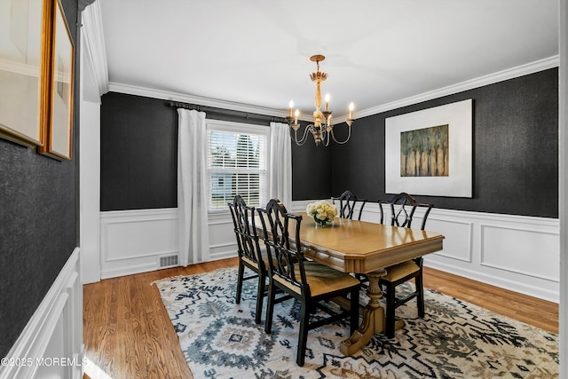 dining area with a notable chandelier, crown molding, and dark hardwood / wood-style floors