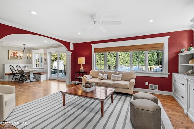 living room featuring ornamental molding, light hardwood / wood-style flooring, and a wealth of natural light