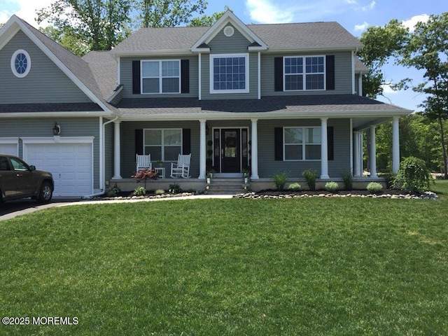 view of front of property featuring a garage, a front lawn, and a porch