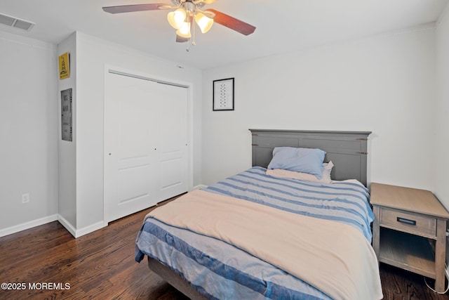 bedroom featuring ceiling fan, dark hardwood / wood-style floors, and a closet