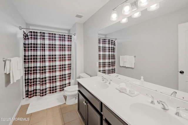 bathroom with tile patterned flooring, vanity, and toilet