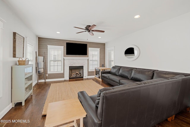 living room featuring dark hardwood / wood-style flooring, ceiling fan, and a healthy amount of sunlight