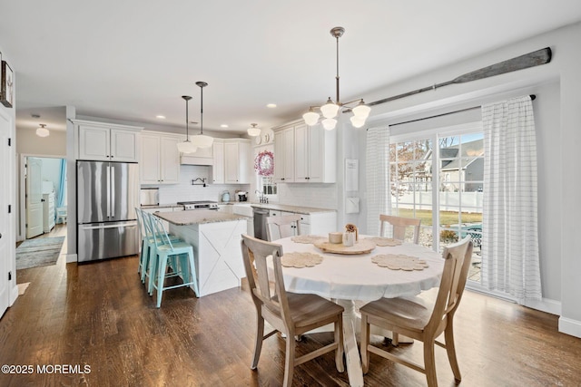 dining room featuring dark wood-type flooring, a chandelier, and a healthy amount of sunlight