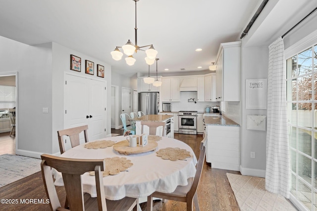 dining area with a notable chandelier and light wood-type flooring