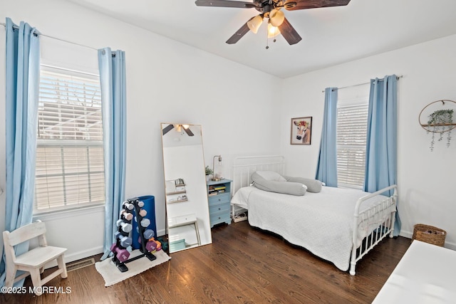 bedroom with dark hardwood / wood-style flooring and ceiling fan