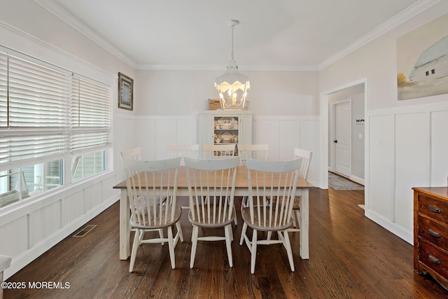 dining space featuring an inviting chandelier, dark hardwood / wood-style flooring, and ornamental molding