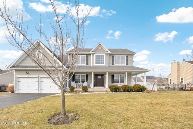 view of front of home featuring a garage, a front yard, and covered porch