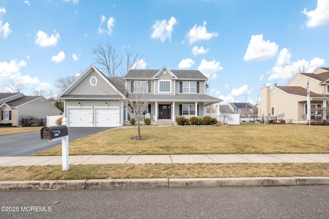 view of front of house featuring a garage, a front yard, and a porch