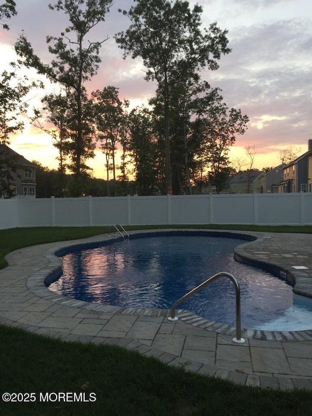 pool at dusk with a patio