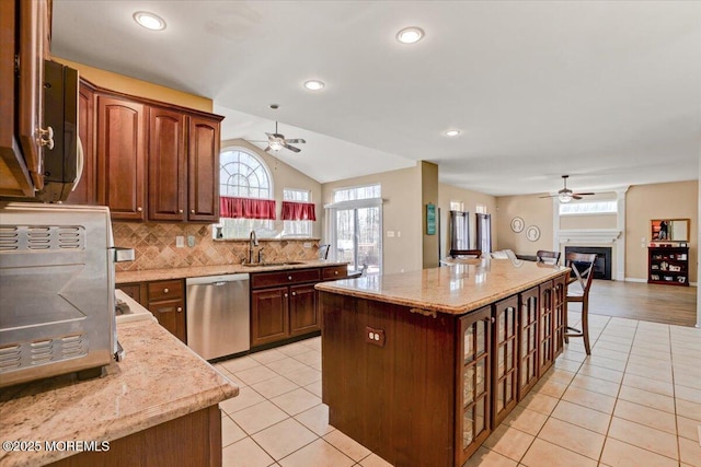 kitchen with dishwasher, a center island, sink, and light tile patterned flooring