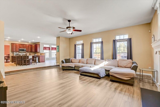 living room with ceiling fan and light wood-type flooring