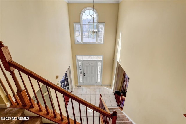 entryway featuring light tile patterned floors, a high ceiling, and a notable chandelier