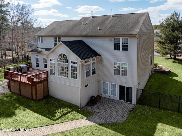 back of house with a deck and a lawn