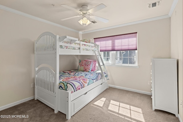 carpeted bedroom with baseboards, visible vents, ornamental molding, and a ceiling fan