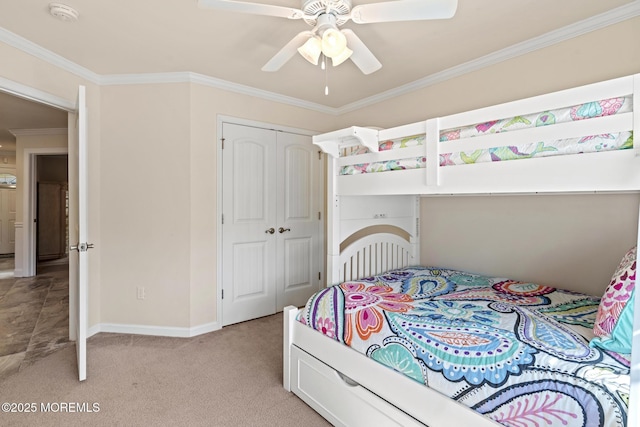 bedroom featuring light colored carpet, a ceiling fan, baseboards, a closet, and crown molding