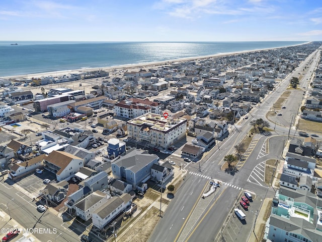 drone / aerial view with a water view and a beach view