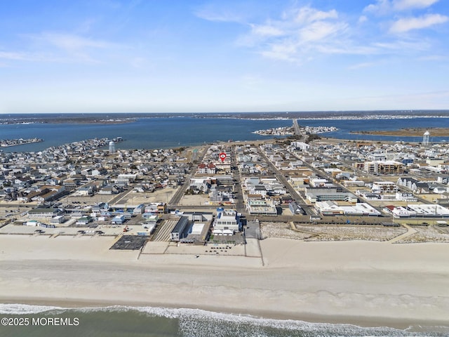 drone / aerial view with a view of city, a water view, and a beach view