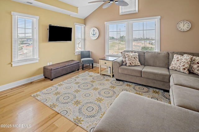 living room with vaulted ceiling, ceiling fan, a healthy amount of sunlight, and hardwood / wood-style floors