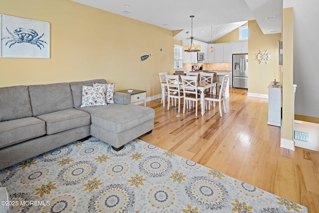 living room with lofted ceiling and light wood-type flooring