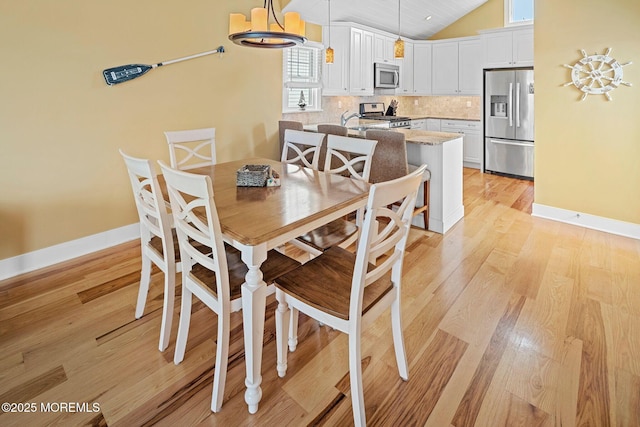 dining area featuring light hardwood / wood-style floors and vaulted ceiling