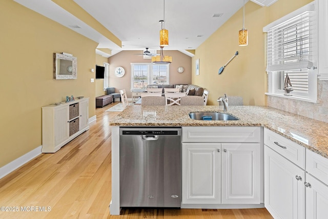 kitchen featuring sink, white cabinets, hanging light fixtures, stainless steel dishwasher, and light wood-type flooring