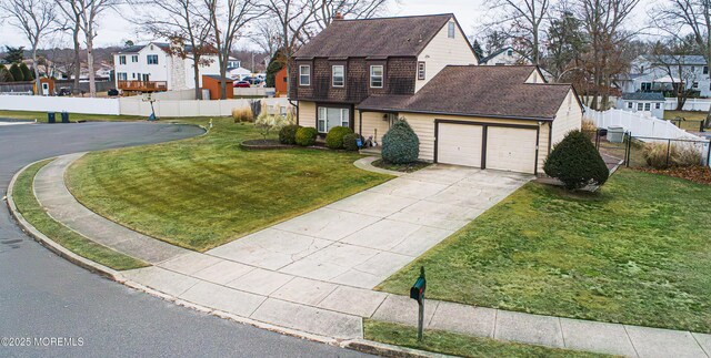 view of front of house featuring a garage and a front lawn