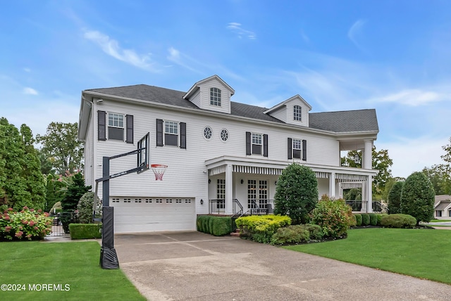 view of front of house featuring a porch, a garage, and a front lawn