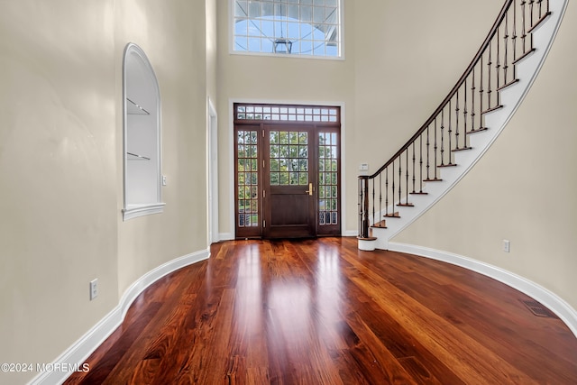 foyer featuring wood-type flooring and a high ceiling