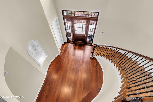 entrance foyer with dark wood-type flooring and a towering ceiling