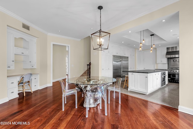 dining space featuring crown molding, built in desk, dark hardwood / wood-style flooring, and a tray ceiling