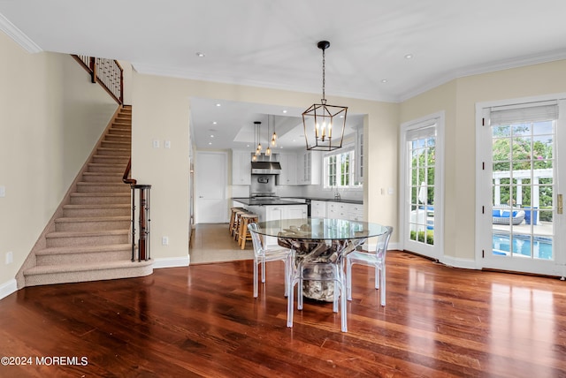 dining area with hardwood / wood-style floors, ornamental molding, and a healthy amount of sunlight