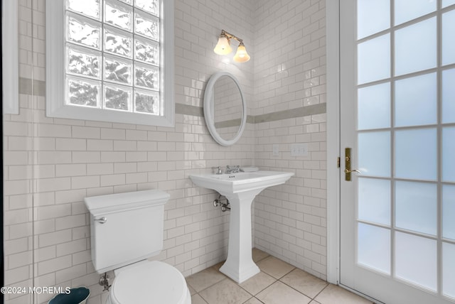 bathroom with tile walls, tile patterned floors, and toilet