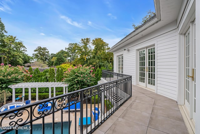 balcony featuring french doors, a patio, and a pergola