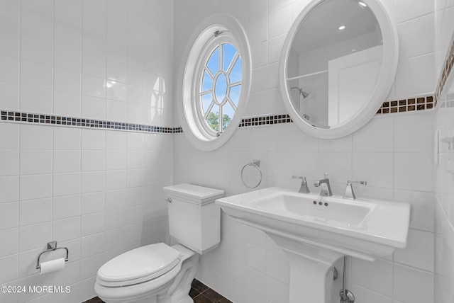 bathroom featuring tile walls and toilet