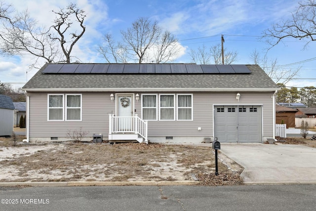 ranch-style house with a garage and solar panels