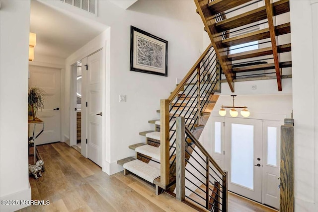 stairway featuring wood-type flooring and french doors