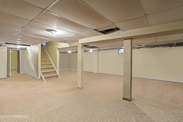 basement featuring a paneled ceiling and carpet