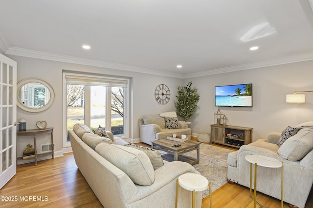 living room featuring crown molding and light hardwood / wood-style floors