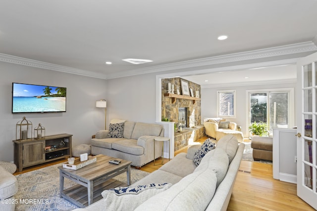 living room with crown molding and light hardwood / wood-style floors