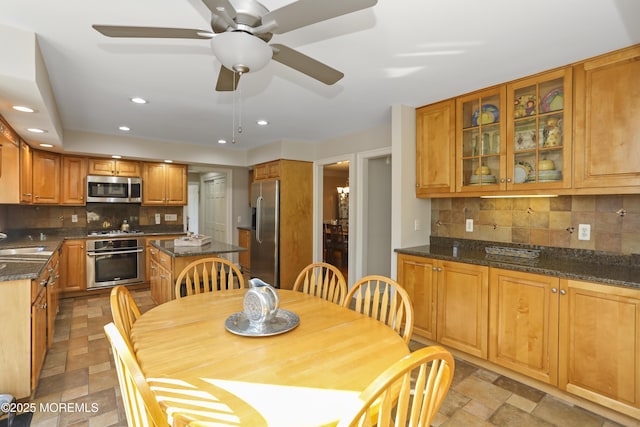 kitchen with dark stone countertops, sink, decorative backsplash, and stainless steel appliances