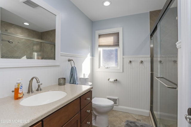 bathroom featuring vanity, toilet, an enclosed shower, and tile patterned flooring