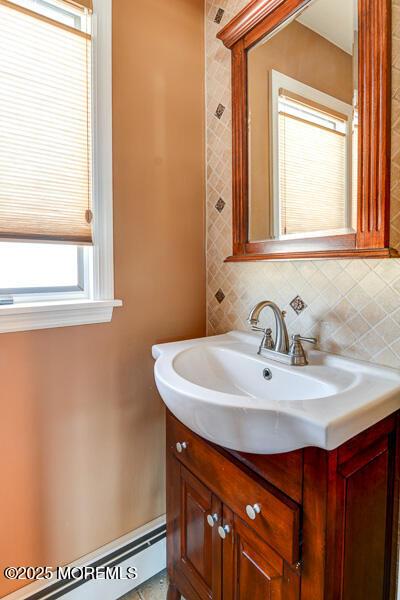 bathroom with tasteful backsplash, a baseboard radiator, and vanity