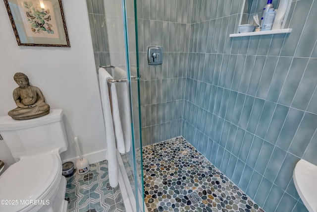 bathroom featuring tile patterned flooring, tiled shower, and toilet