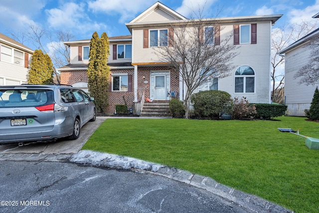 multi unit property with brick siding and a front lawn