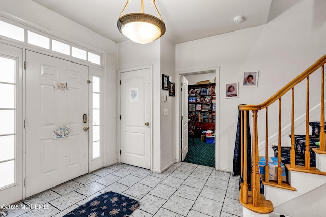 entryway with stairway and baseboards