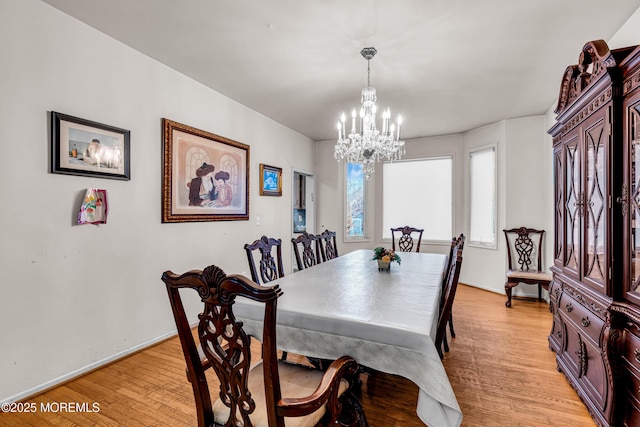 dining room with an inviting chandelier, light wood-style floors, and baseboards
