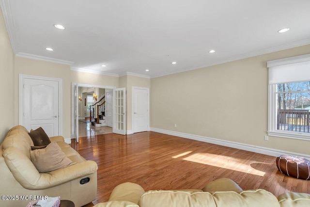 living room featuring wood-type flooring and crown molding